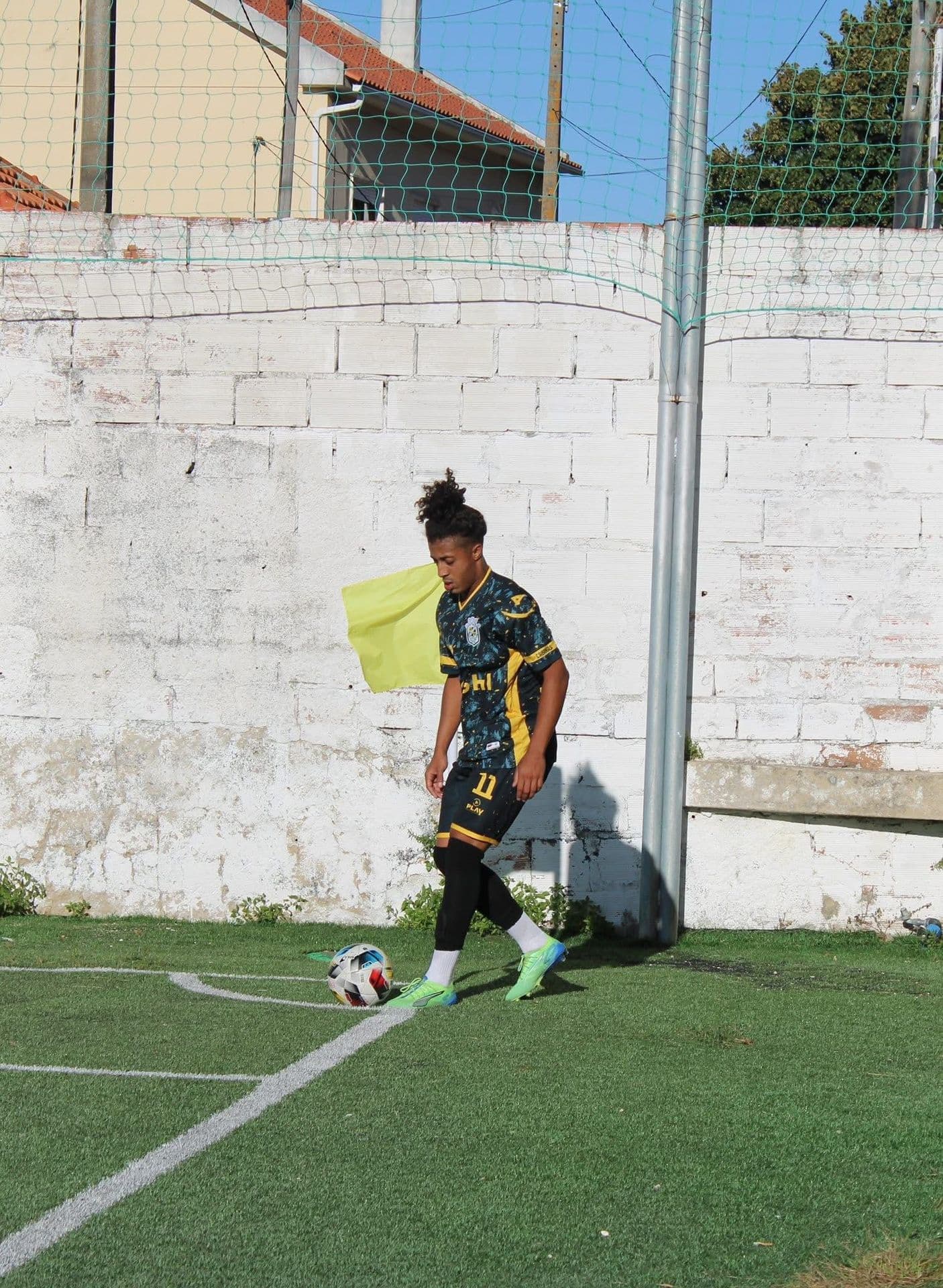 Footballer by the touchline in a custom kit